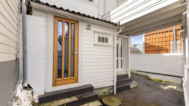 Uteområdet mellom hovedhuset og annekset, med adkomst til flere av enhetene.