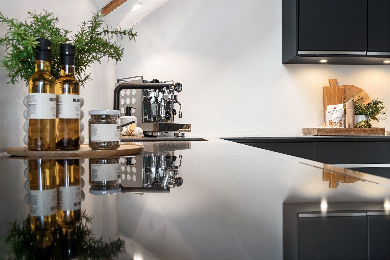 Gjennomtenkte materialvalg med nedfelt kum og benkeskapsbelysning understreker kjøkkenets kvalitet.