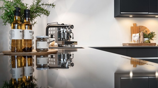 Gjennomtenkte materialvalg med nedfelt kum og benkeskapsbelysning understreker kjøkkenets kvalitet.