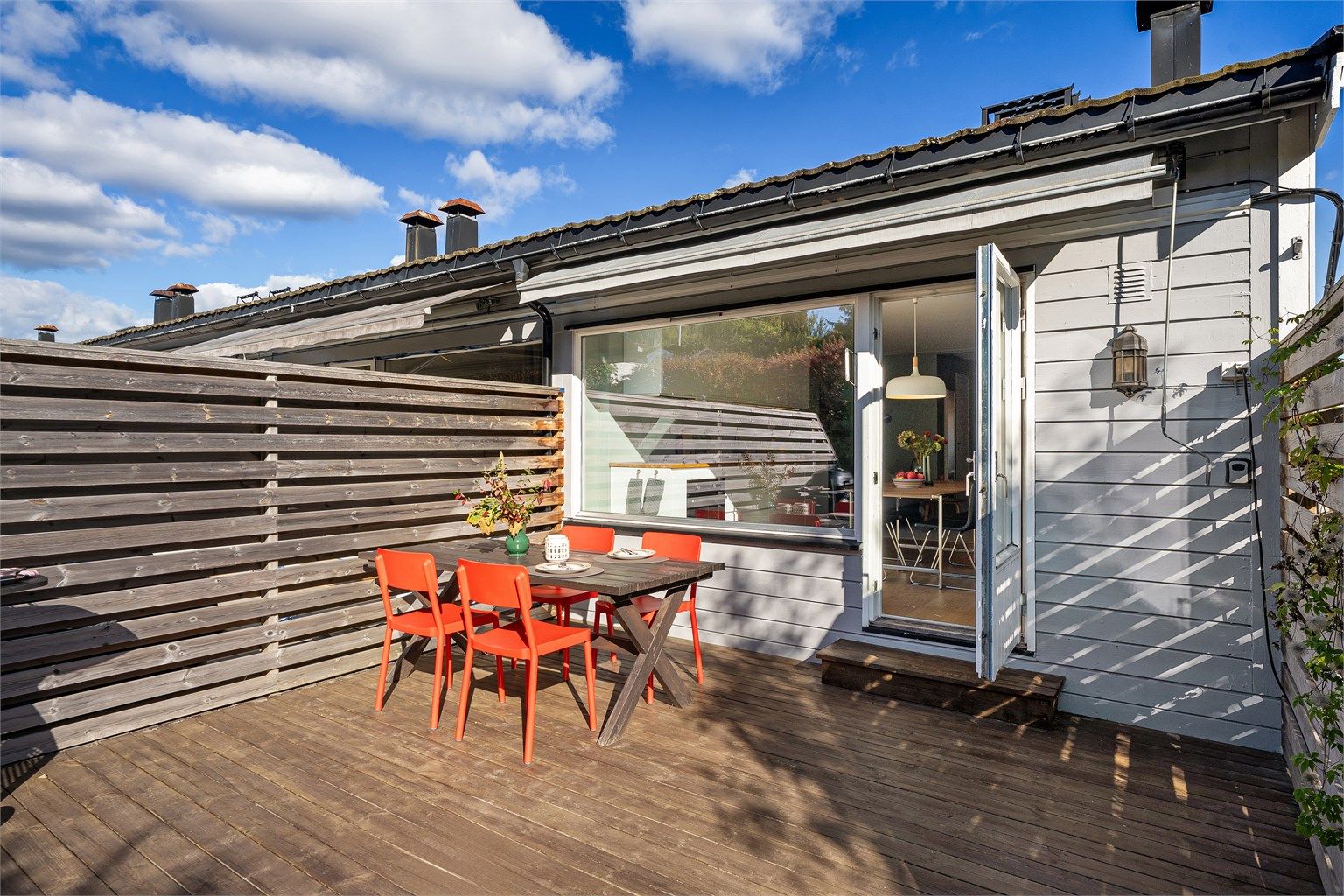 Skjermet markterrasse i trekonstruksjoner med god plass til spisebord og grill.