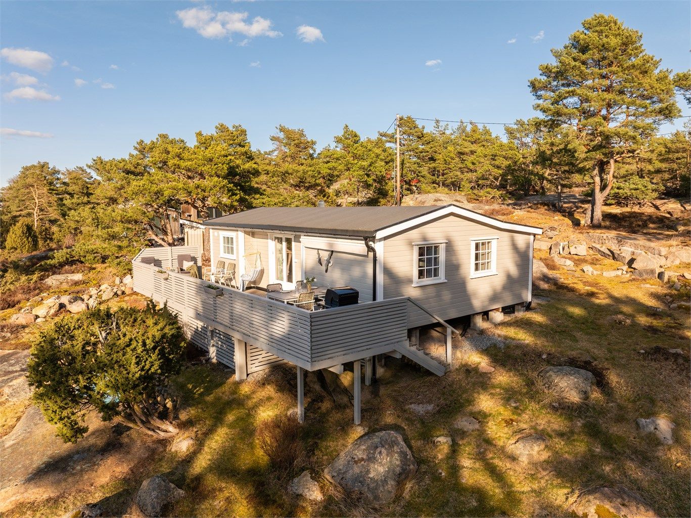 Trapp i begge ender av terrassen gir enkel tilgang til terrenget rundt hytta.