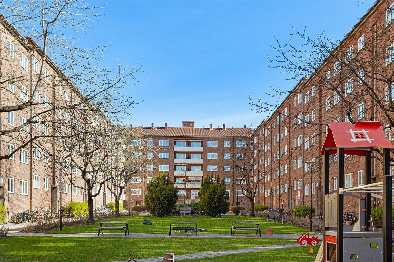 Store, grønne fellesarealer med lekeplass mellom bygårdene.