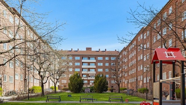 Store, grønne fellesarealer med lekeplass mellom bygårdene.