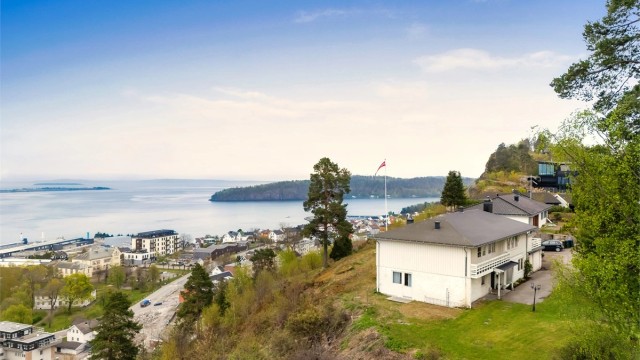 Boligen har en stor tomt på 2 453 kvm - med både flate plenarealer, og skrående naturtomt