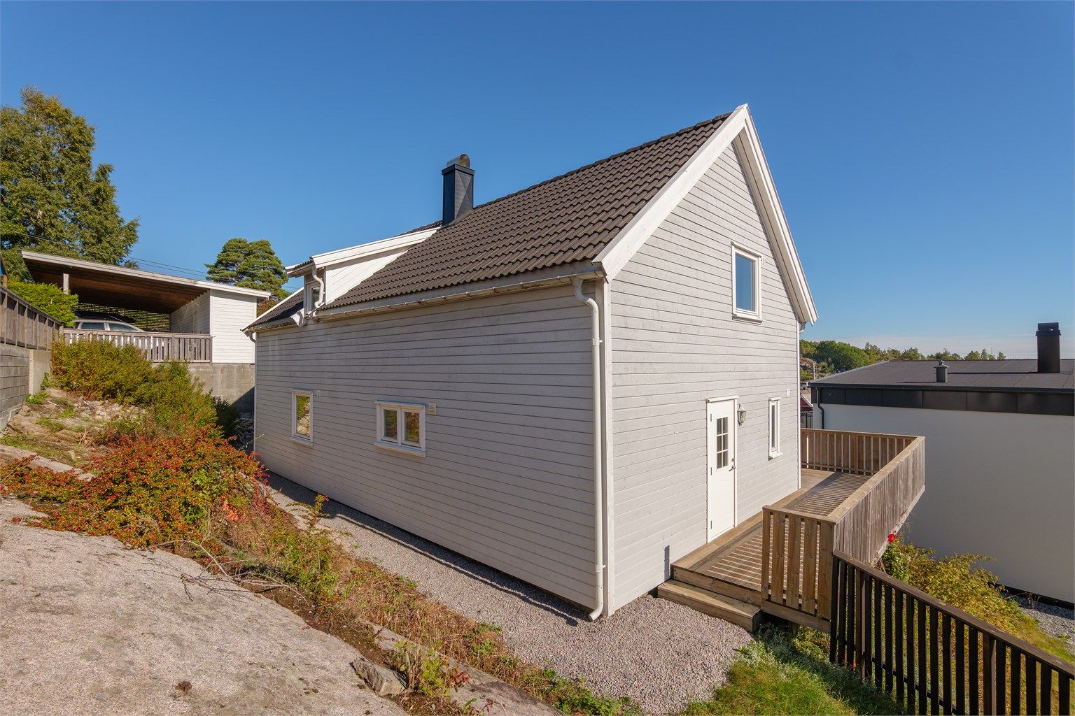 Gruslagt gangvei ved siden av huset. Sydøstvendt terrasse.