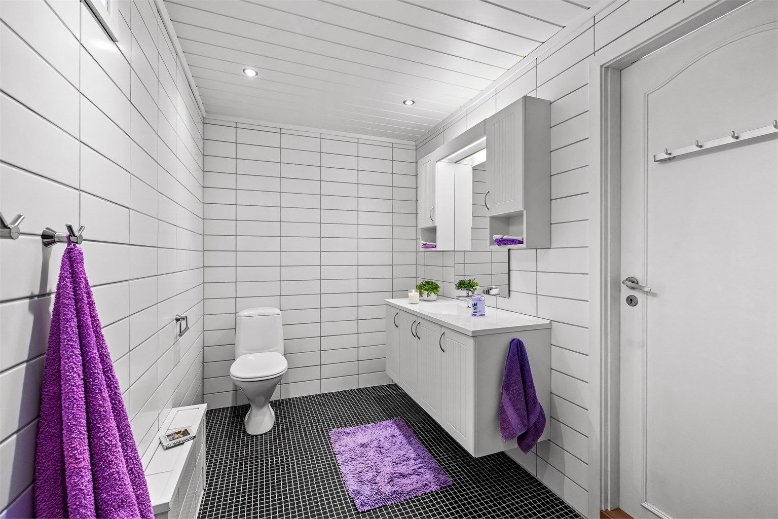 Rommet har flislagte overflater, vegghengt servantskap og panel i himling med downlights.