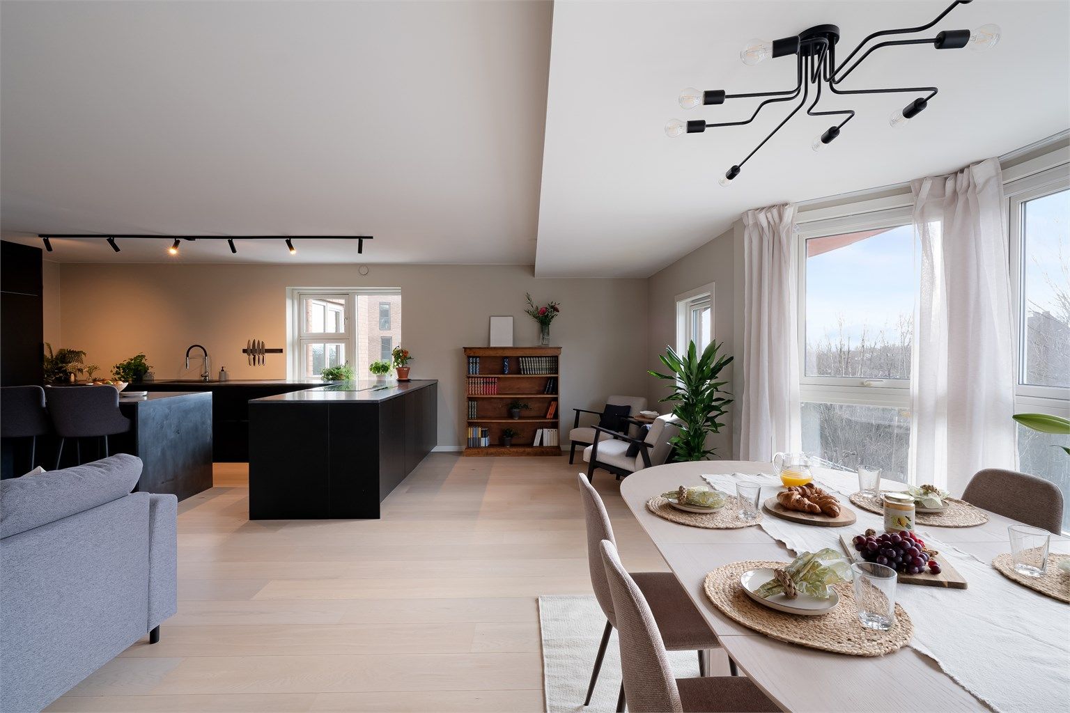 Den åpne løsningen mot kjøkkenet gjør rommet lett å møblere etter egen smak og skaper en sosial atmosfære.