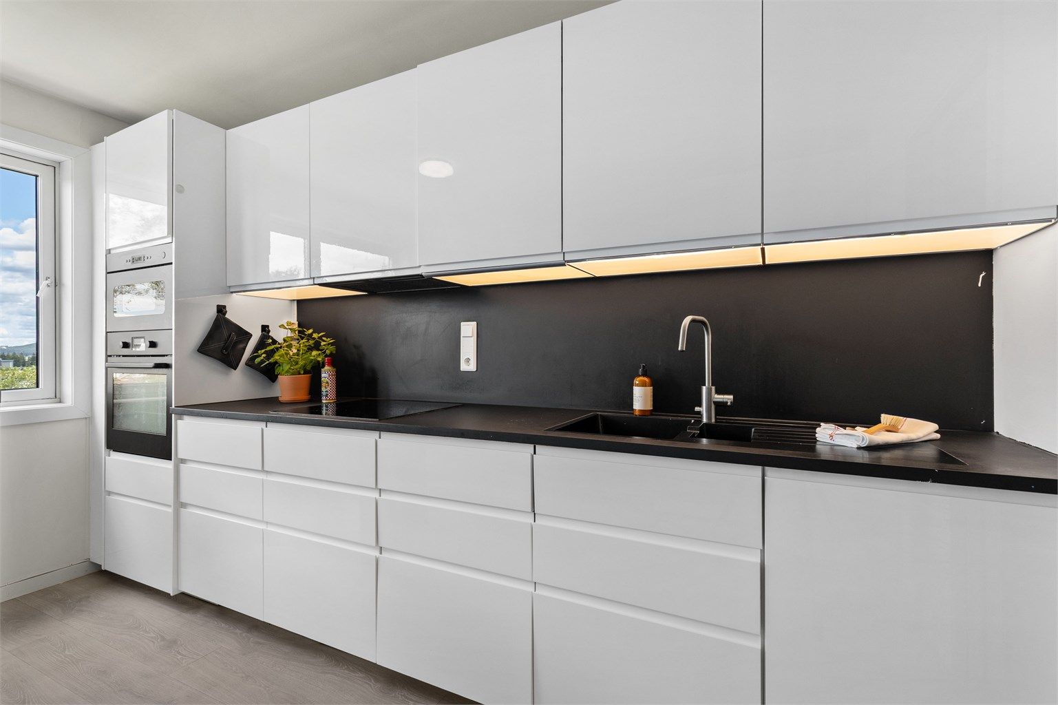 Glatte fronter og integrerte løsninger gir kjøkkenet et stilrent og tidløst uttrykk.