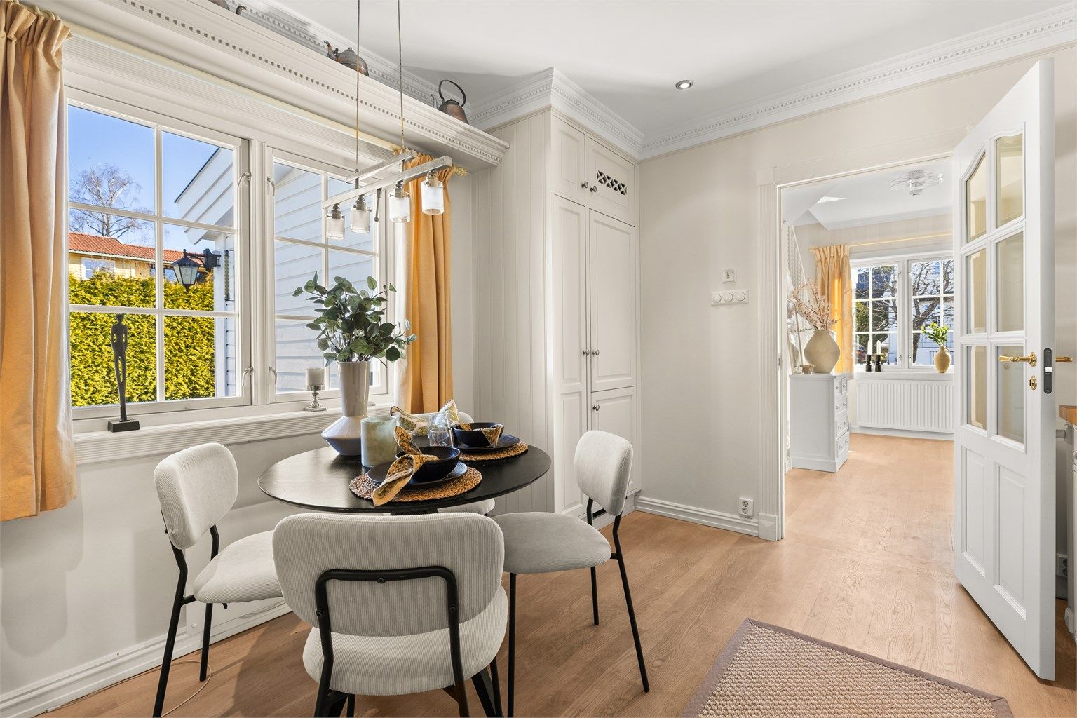 Hyggelig kjøkken med stukkatur og plass til spisebord ved vinduet