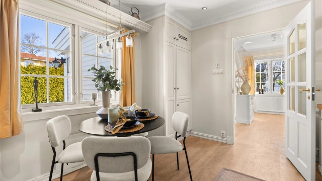 Hyggelig kjøkken med stukkatur og plass til spisebord ved vinduet