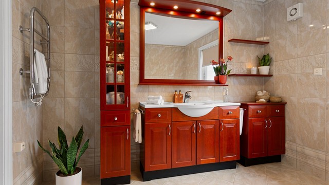 Stort flislagt bad med gulvvarme. Innredet med gulvstående servantskap med profilerte fronter og ovenpåliggende servant.