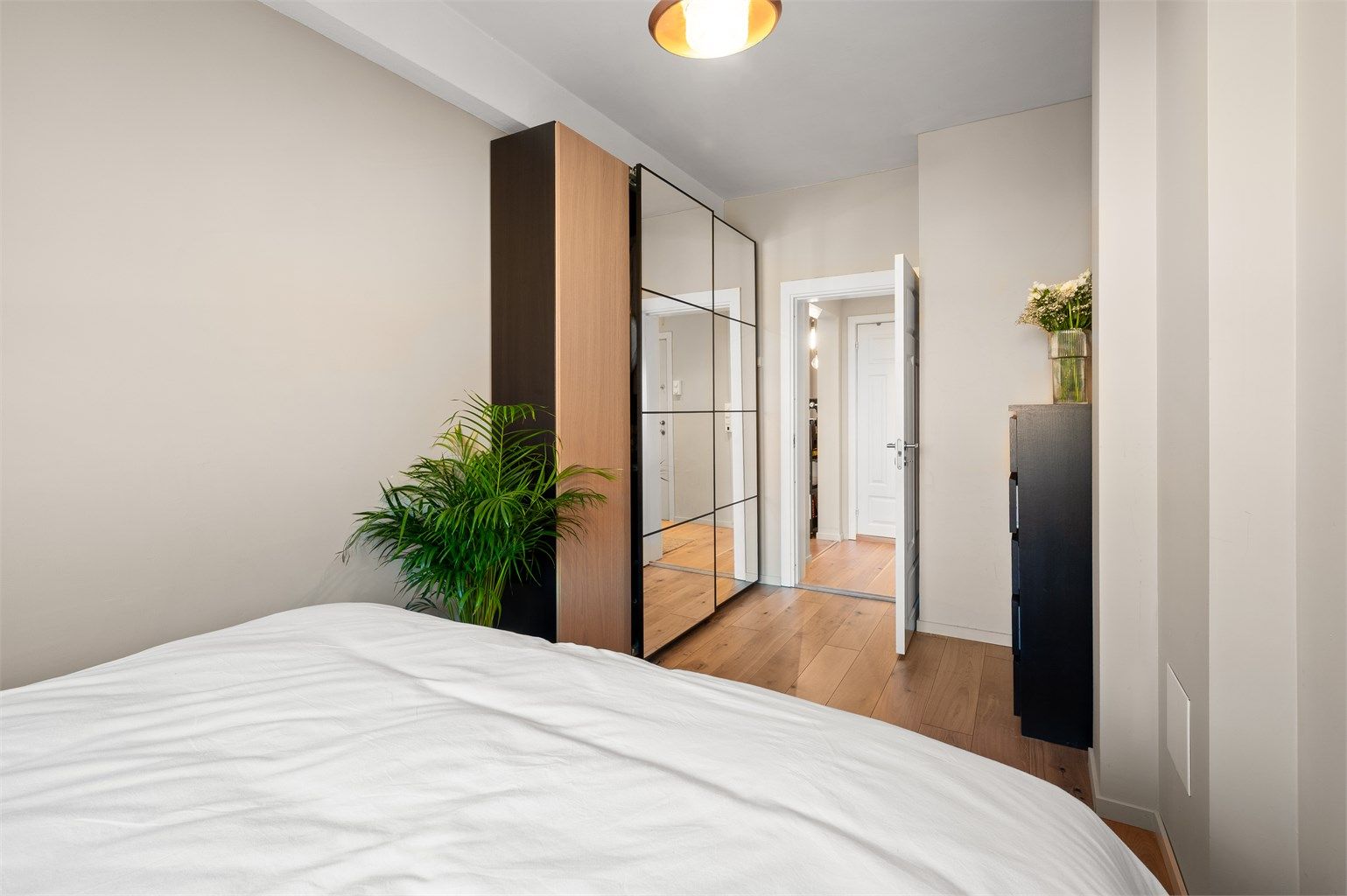 Romslig garderobeløsning med speilfronter gir rikelig med oppbevaring på soverommet.