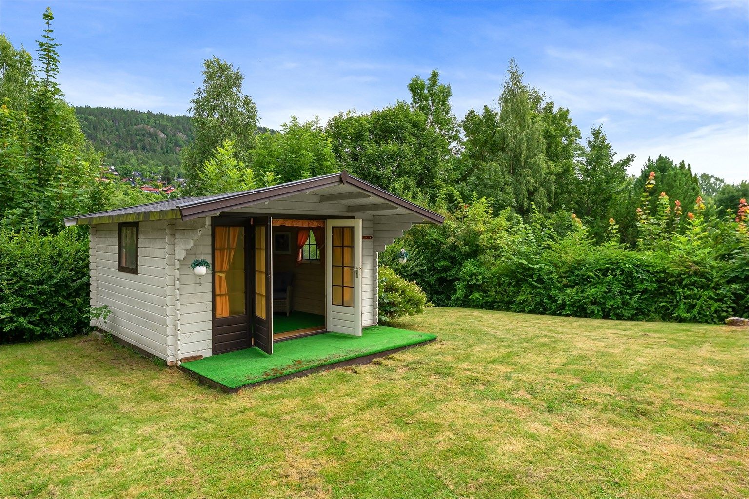 Frittstående utestue i hagen, et hyggelig tilleggsrom for sommerhalvåret.