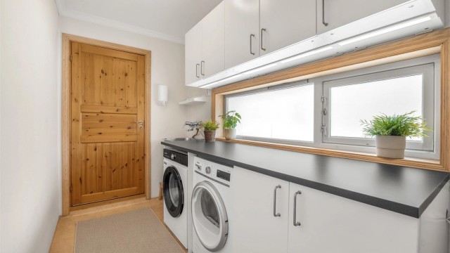 Separat vaskerom i første etasje med skapinnredning, utslagsvask og opplegg for vaskemaskin/tørketrommel.