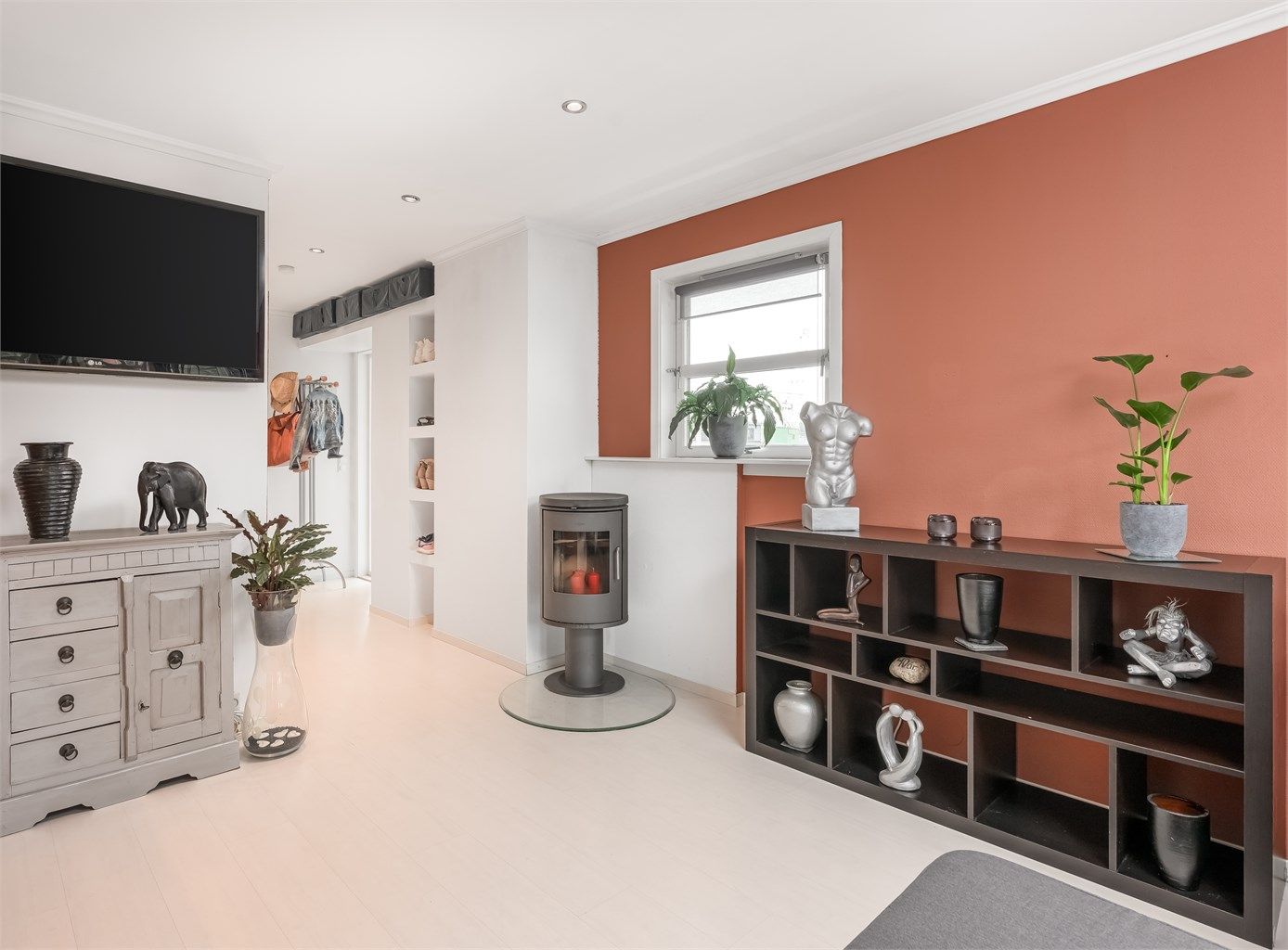 Stuen har peisovn, downlights i himling og lyse laminatgulv