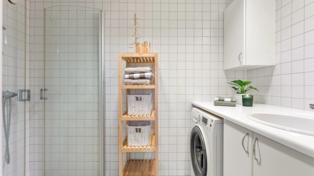 Flislagt bad med oppvarmet gulv og opplegg for vaskemaskin.