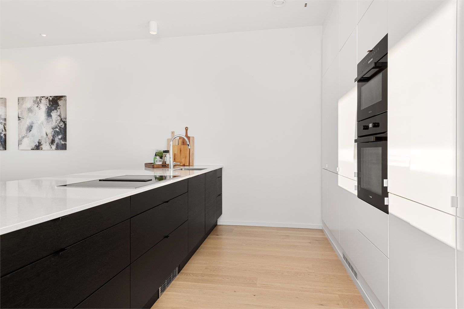 Stor og romslig kjøkkenøy mot stue/spisestue. Kjøkkenøyen har skap på begge sider og gode oppbevaringsmuligheter