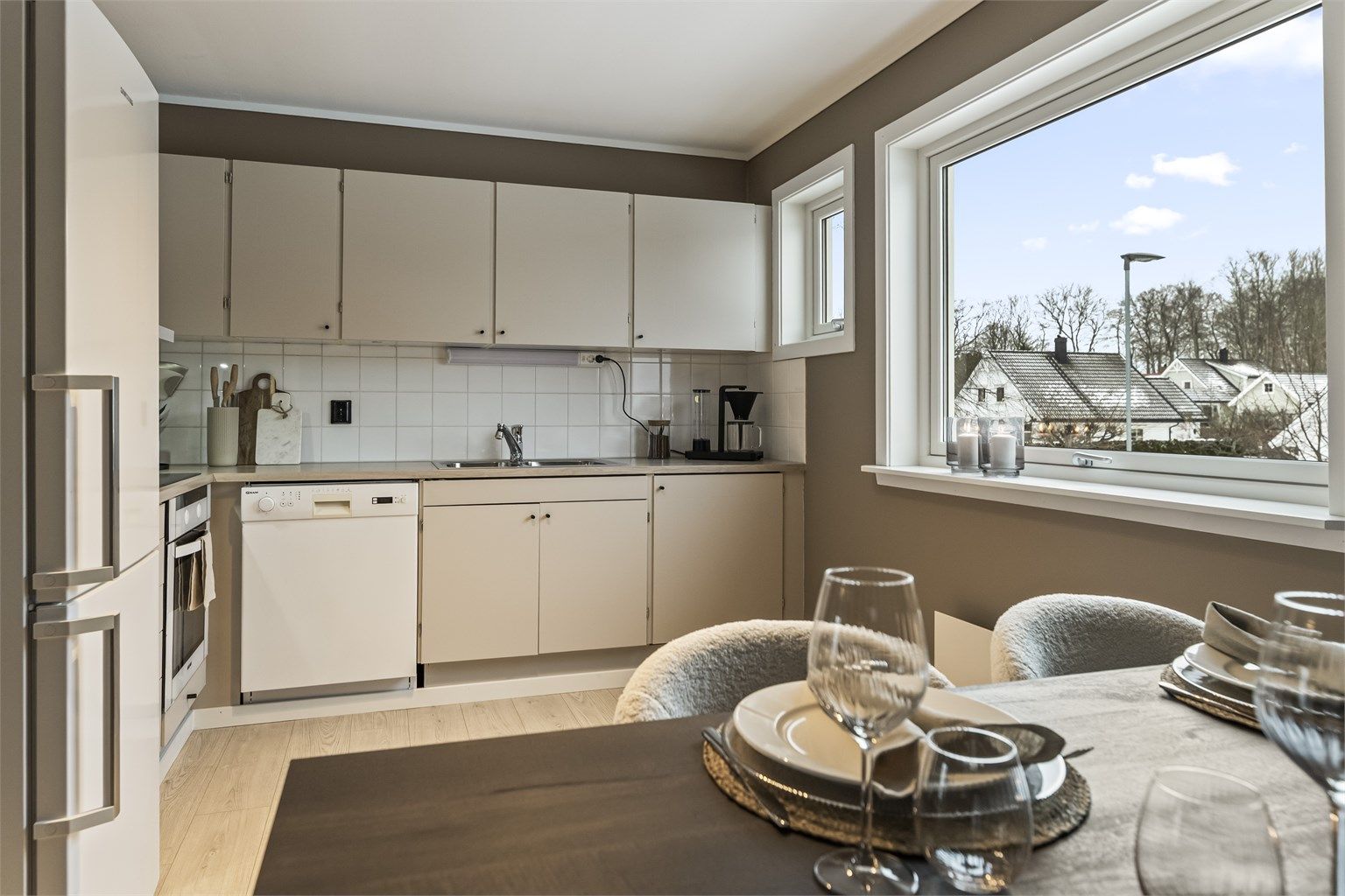 Smakfullt kjøkken med malte fronter og flis over benkeplaten