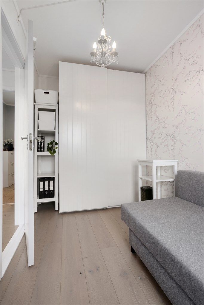 Rommet har en dekorativ tapetvegg, skyvedørsgarderobe og parkett på gulv.