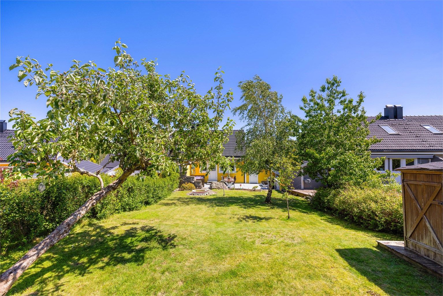 På borettslagets tomt disponerer boligen en romslig og fin hage med tumleplass for familien og store blomsterbed anlagt i senere år.