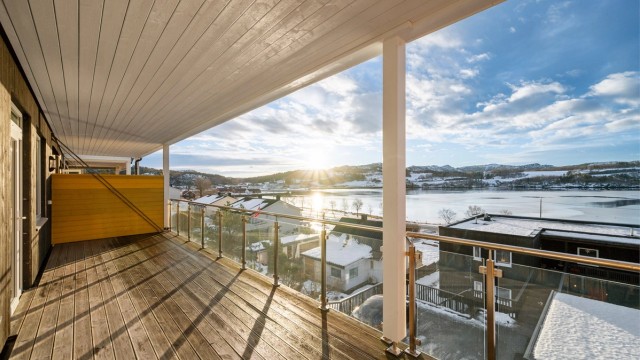 Eiendommen ligger i et stille og rolig område, omkranset av naturskjønne omgivelser og et vakkert fjordlandskap. Fra stuen har man direkte utgang til en overbygd balkong på hele 26,4 kvm.