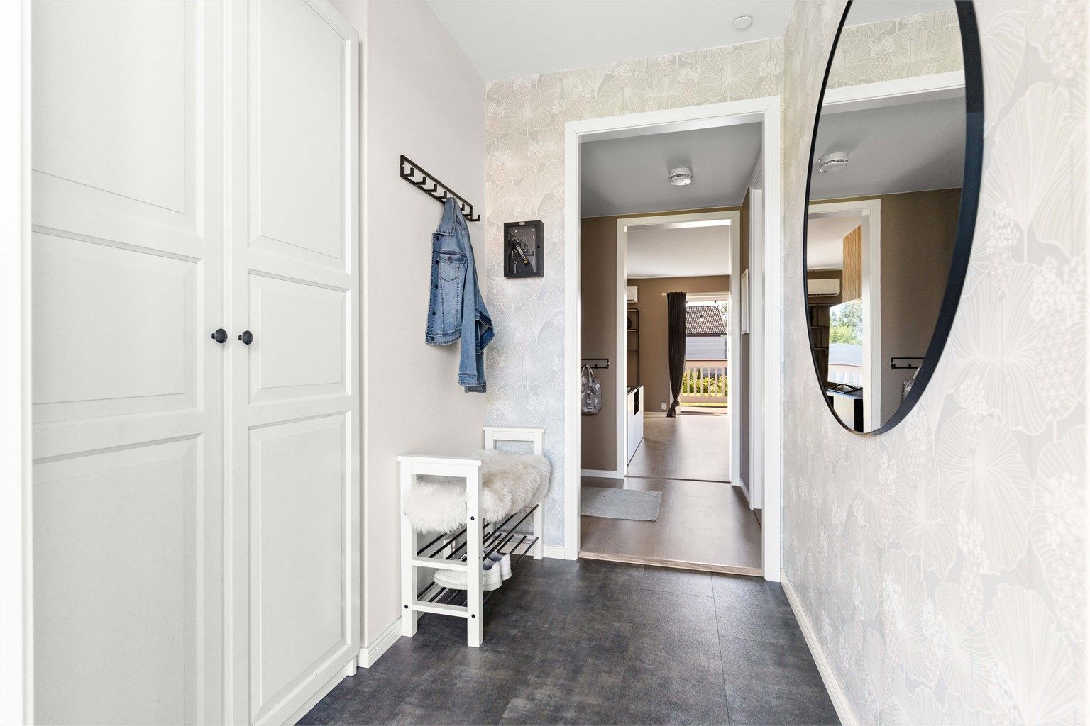 Lys og delikat entré som gir et godt førsteinntrykk av leiligheten. Praktisk gulvvarme og god oppbevaringsplass til yttertøy i garderobeskap.