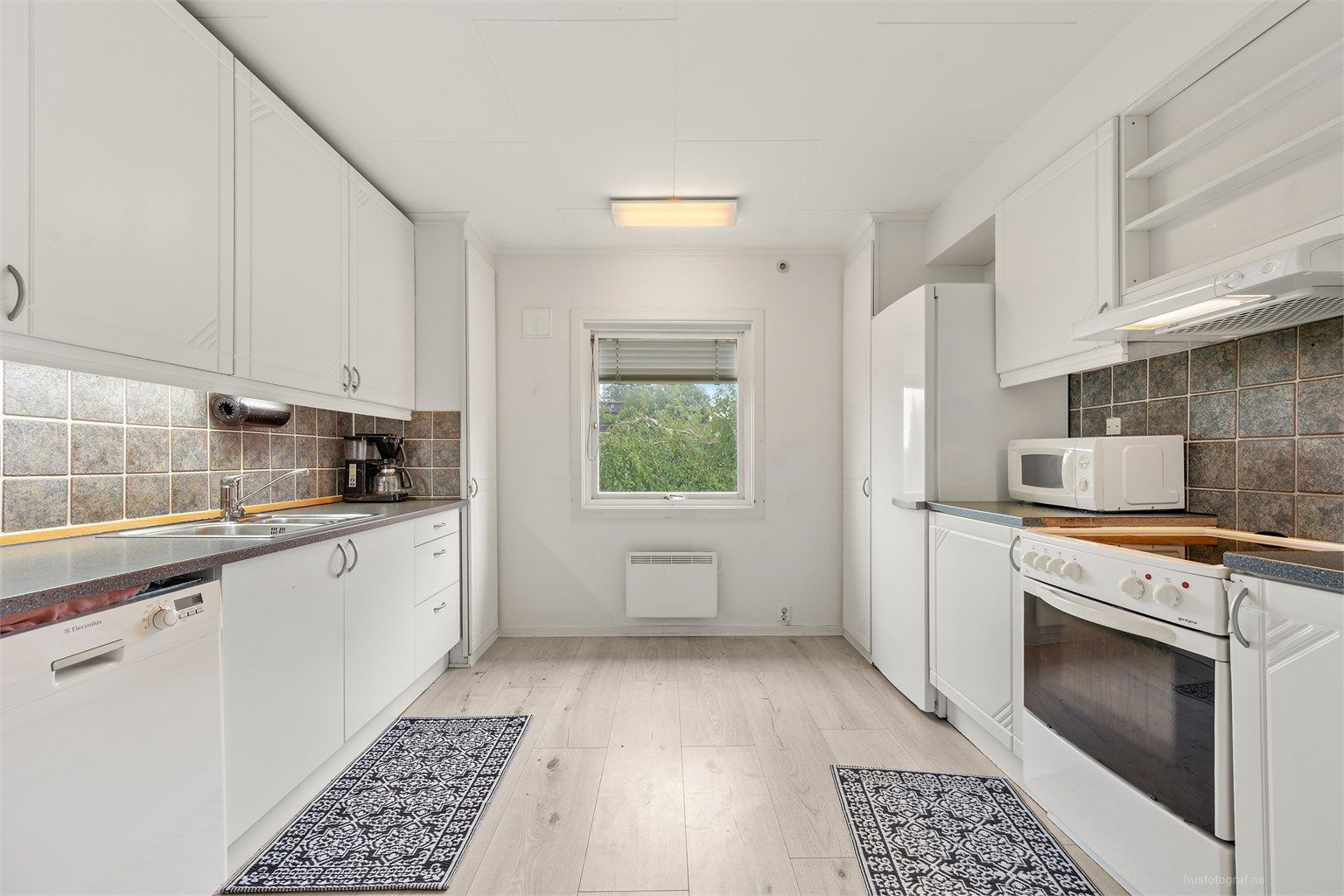 Lys kjøkkeninnredning med slette fronter og benkeplate av laminat 