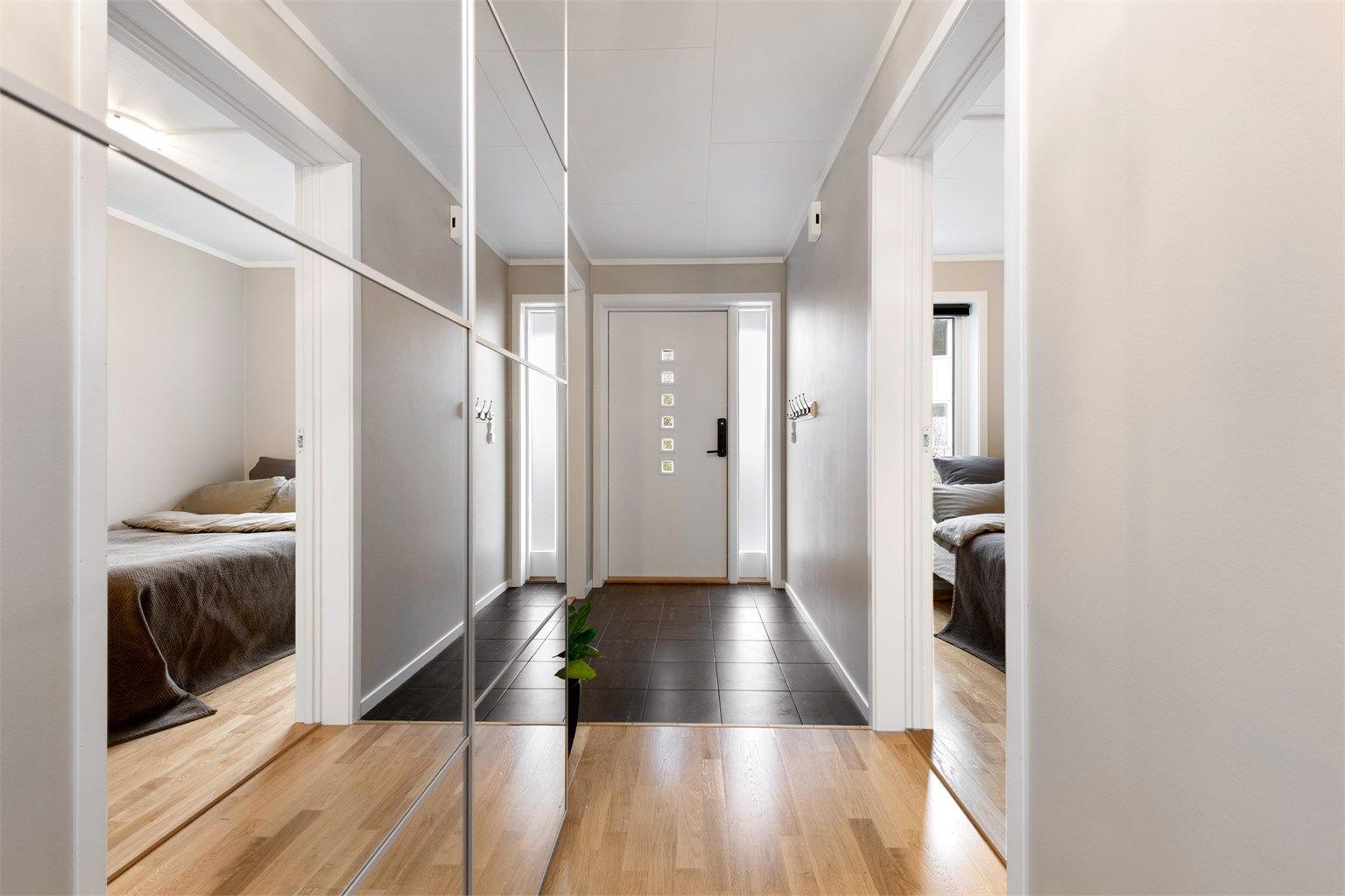 Velkommen inn. Entréen har flislagt gulv med varmekabler for komfort, og en praktisk skyvedørsgarderobe. Ytterdøren er utstyrt med elektronisk kodelås.