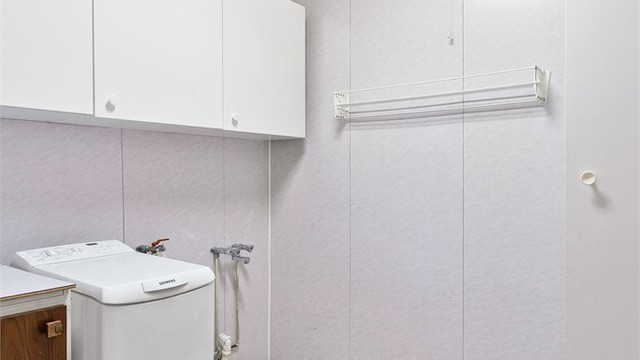 Vaskerom med flislagt gulv. Innredet med gulvstående innredning med utslagsvask. Opplegg for vaskemaskin.