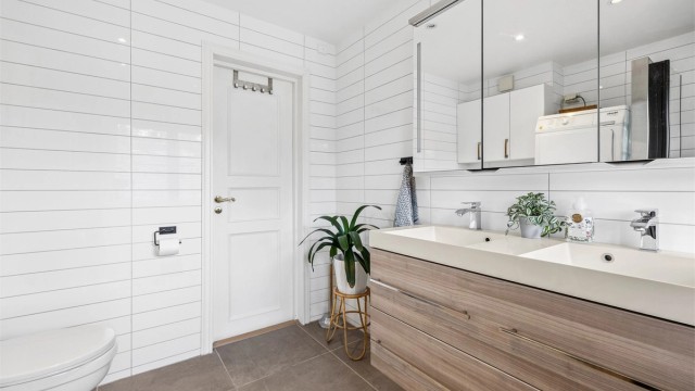 Bad i 2. etasje med innredning fra Linn Bad, doble servanter og gulvvarme. Gulvflisene ble lagt i 2020.