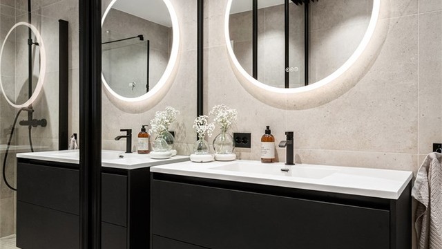 Badet er innredet med servant, vegghengt toalett og en praktisk dusjnisje med plassbesparende glassdører.