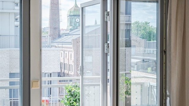 Store vindusflater og balkongdøren i tre gir en sømløs overgang mellom oppholdsrommet og den solrike uteplassen. Vinduer og balkongdør er utført med tolags isolerglass, noe som gir god lydisolasjon.