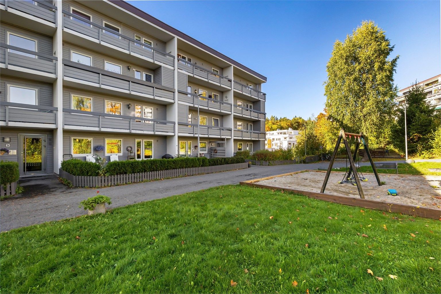 Velholdt boligblokk i Åsterud boligsameie med lekeplass og grøntarealer på tunet.