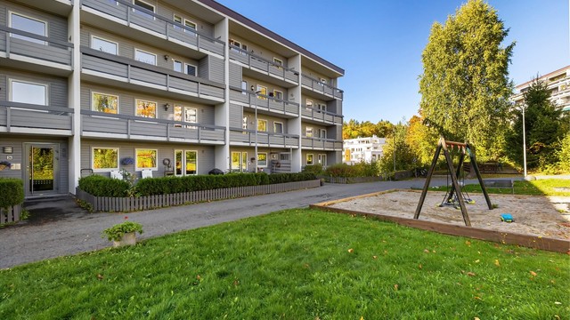 Velholdt boligblokk i Åsterud boligsameie med lekeplass og grøntarealer på tunet.