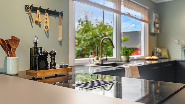 Kjøkkenet har benkeplater av stein og nedfelt induksjonstopp med integrert ventilator.