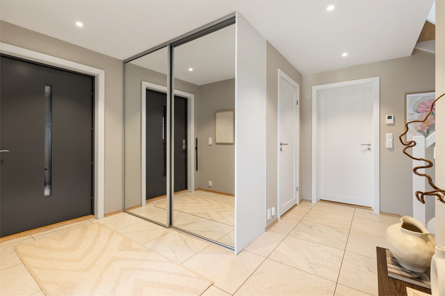 Romslig entré med skyvedørsgarderobe for god oppbevaring av yttertøy.