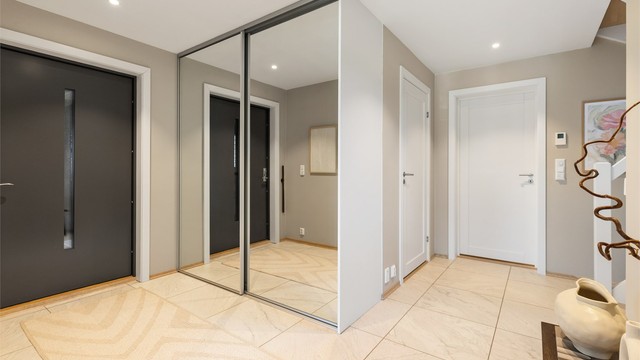 Romslig entré med skyvedørsgarderobe for god oppbevaring av yttertøy.