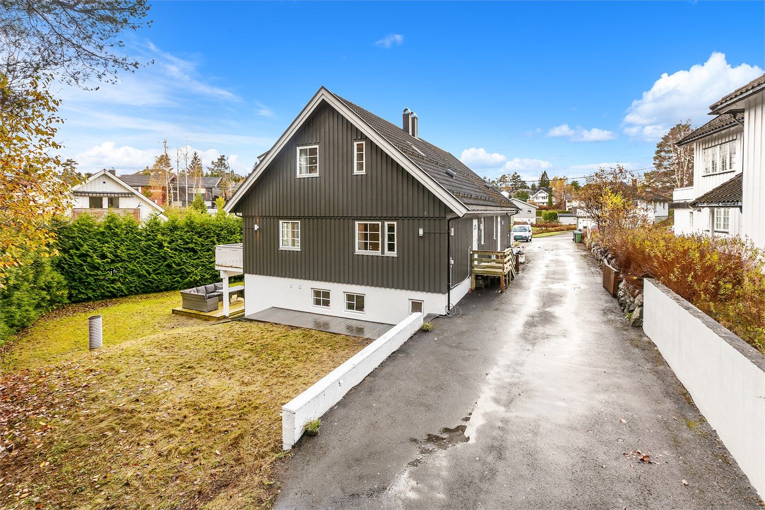 Asfaltert adkomstvei og gårdsplass samt en stor hage med hekk som gir lite innsyn. 