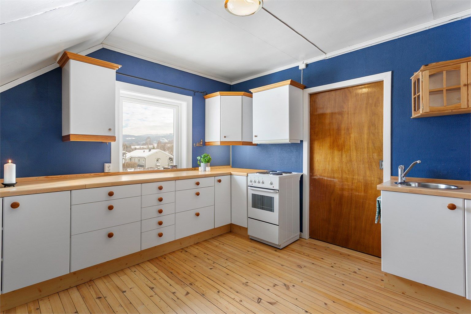 Kjøkken i hybelen med innredning med glatte fronter. Laminert benkeplate med nedfelt oppvaskkum