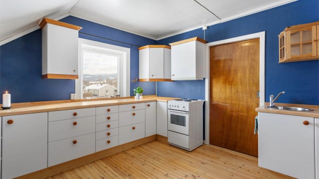 Kjøkken i hybelen med innredning med glatte fronter. Laminert benkeplate med nedfelt oppvaskkum