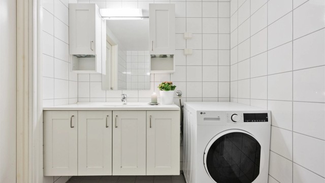 Moderne baderom med vegghengt servantinnredning, speil og overlys.
