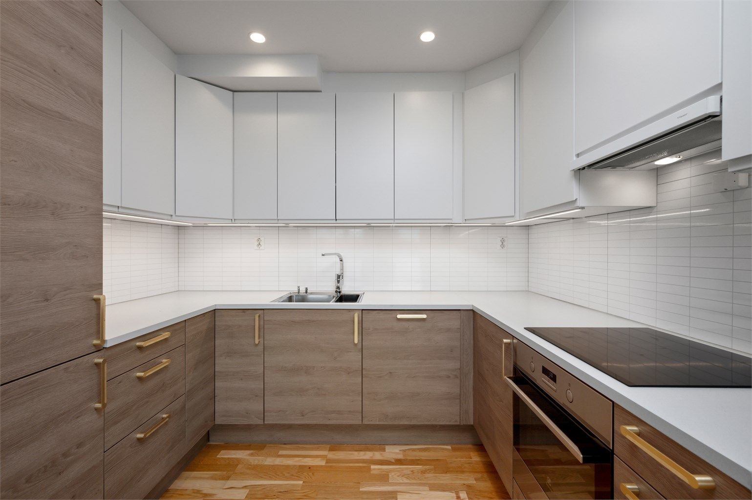 Nydelig kjøkken med integrert kjøleskap, vaskemaskin, komfyr og platetopp. 