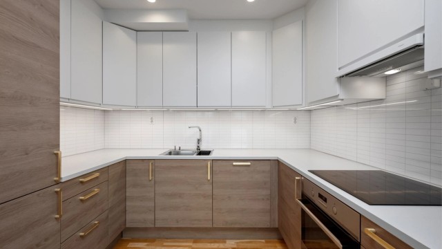 Nydelig kjøkken med integrert kjøleskap, vaskemaskin, komfyr og platetopp.