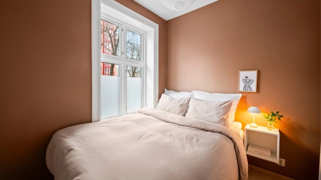 Hovedsoverommet har god plass til dobbeltseng med nattbord. Rommet vender ut mot sidegate.