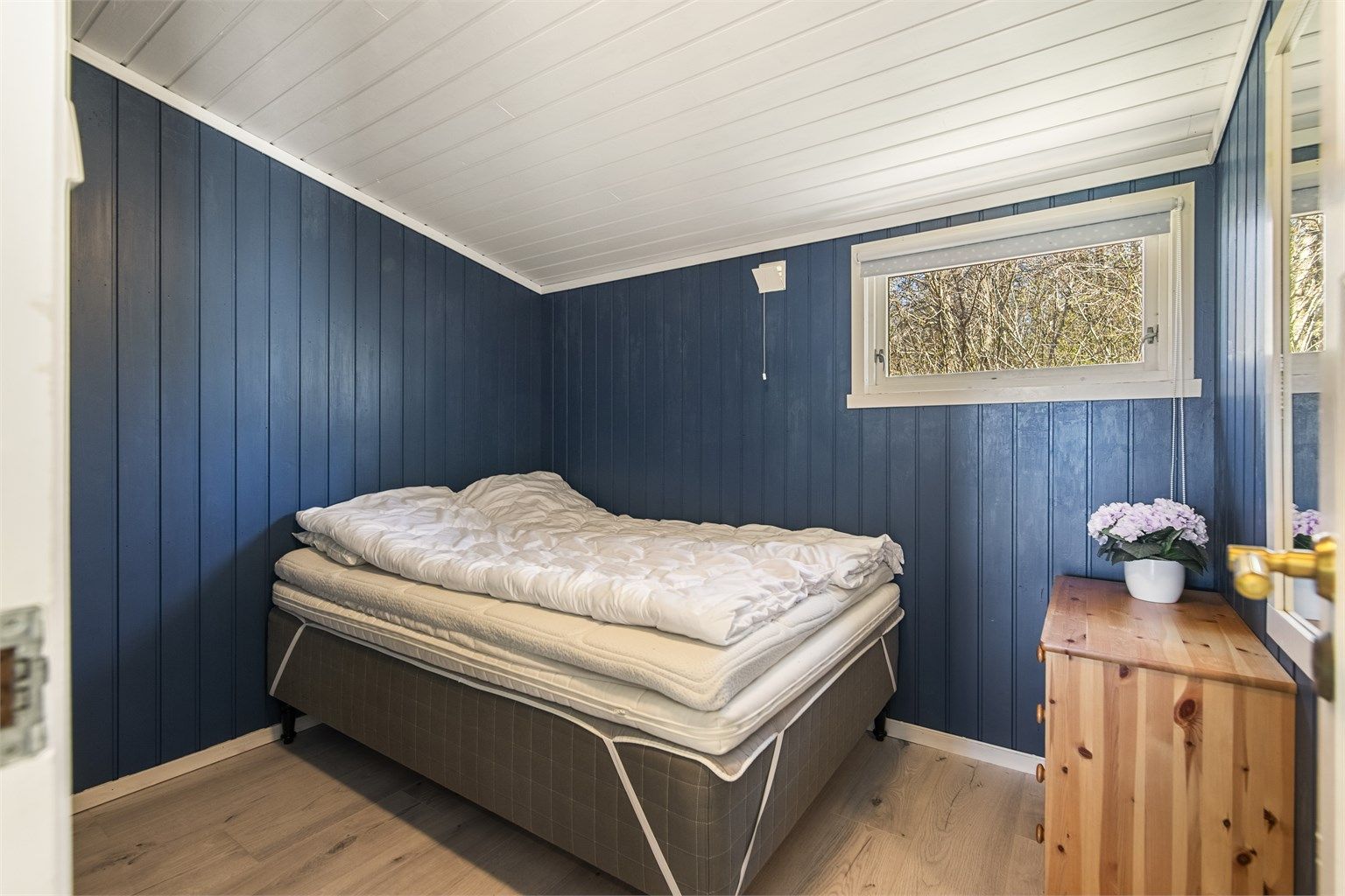 Lyst og romslig hovedsoverom med maritimt fargevalg (ikke søkt eller godkjent for varig opphold).