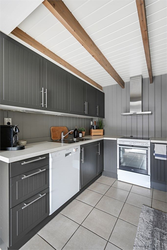 Kjøkkeninnredningen har moderne, mørke fronter og laminat benkeplate.
