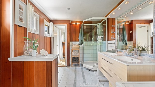 Badet i første etasje har flislagt gulv med gulvvarme, dobbel servant og dusjkabinett.