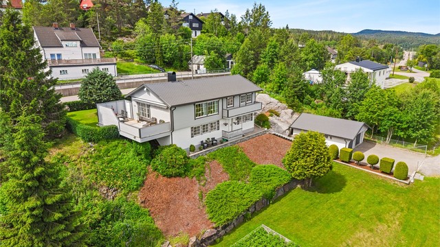 Pent opparbeidet innkjørsel og gårdsplass med belegningsstein.