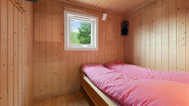 Det andre soverommet har plass til seng og er lunt med panel på veggene