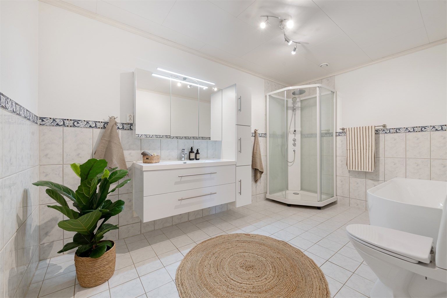 Badet i underetasjen er romslig og utstyrt med både badekar og dusjkabinett.